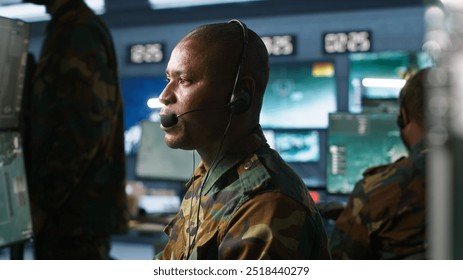 Army telecommunication systems operator using radio gear, providing combat support, doing patriotic duty. African american military dispatcher managing communications networks, camera A