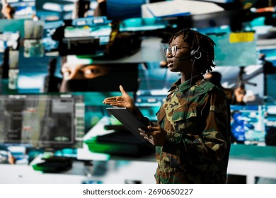 Army telecommunication systems operator using satellite software on tablet, providing combat support. Military dispatcher managing communications networks with digital device