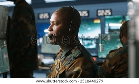 Army telecommunication systems operator using radio gear, providing combat support, doing patriotic duty. African american military dispatcher managing communications networks, camera A