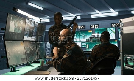 Army telecommunication systems operator using radio and satellite equipment. Middle Eastern military dispatcher managing communications networks, looking at screens, camera B
