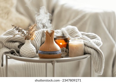 Aroma composition with a modern aroma oil diffuser and a knitted element. - Shutterstock ID 2347809271
