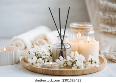 Aroma diffuser, burning candle, cherry blooming flowers and perfume on wooden bamboo tray. Cozy home decor, hygge and aromatherapy concept. Comfortable atmosphere, spring delicious fresh smell - Shutterstock ID 2301388423