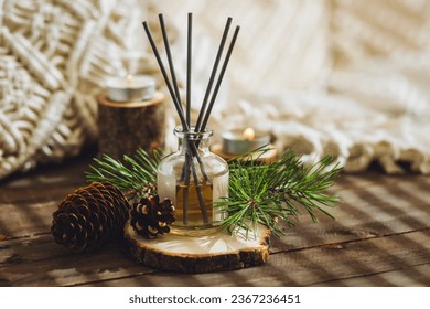 Aroma diffuser, burning candle, pine essential oil and perfume on wooden table. Cozy home decor, hygge and aromatherapy concept. Comfortable atmosphere, fresh smell - Powered by Shutterstock