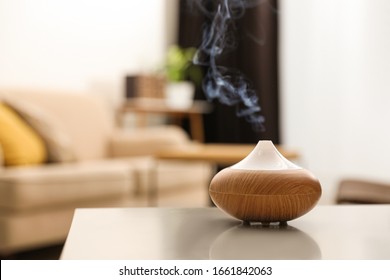 Aroma oil diffuser on light table at home, space for text. Air freshener