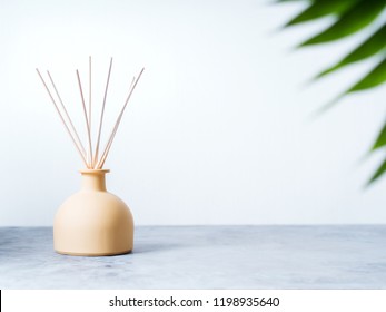 Aroma Reed Diffuser Home Fragrance With Rattan Sticks On A Light Background With Palm Leaves And Shadows. 