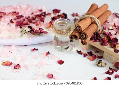 Aroma Spa Treatment. Pink Epsom Bath Salt, Essential Cinnamon Oil In Bottle, Rose Petals Scattered.