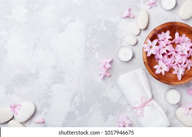 Aromaterapia, beleza, fundo spa com seixo de massagem, flores perfumadas água e velas na vista de cima da mesa de pedra. Relaxamento e conceito zen. Deitado liso.