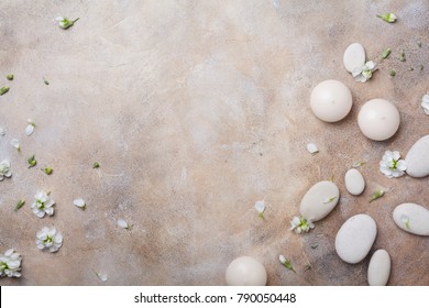 Aromatherapy, beauty and spa background with massage pebble and candles decorated with white flowers. Relaxation and zen like concept. Top view