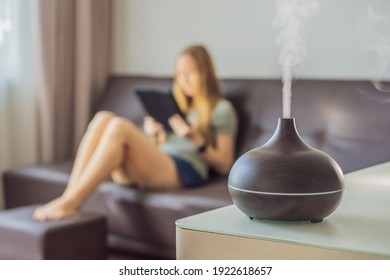 Aromatherapy Concept. Wooden Electric Ultrasonic Essential Oil Aroma Diffuser and Humidifier. Ultrasonic aroma diffuser for home. Woman resting at home