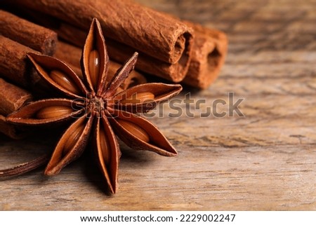Aromatic anise star and cinnamon sticks on wooden table, closeup