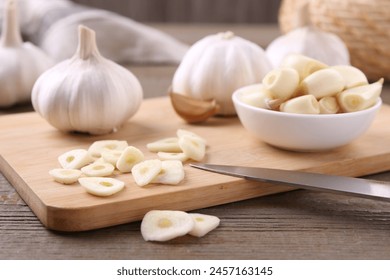 Aromatic cut garlic, cloves and bulbs on wooden table, closeup - Powered by Shutterstock