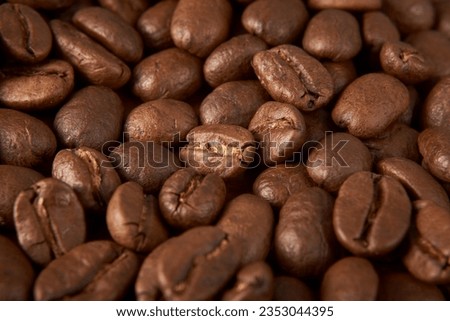 Aromatic Elegance: A close-up masterpiece capturing the intricate details of coffee beans on a rich wooden texture. The interplay of texture and aroma unfolds against a warm backdrop