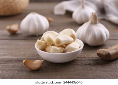 Aromatic garlic cloves and bulbs on wooden table, closeup