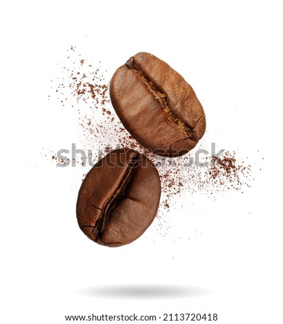 Aromatic ground coffee and beans falling on white background