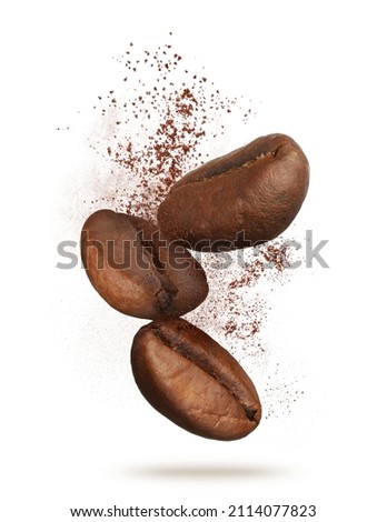 Aromatic ground coffee and beans falling on white background
