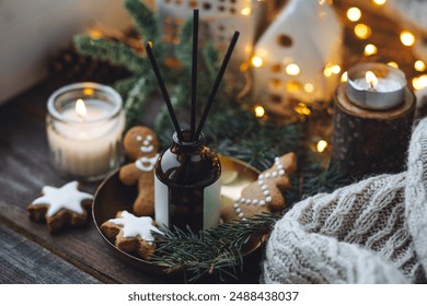 Aromatic home apartment diffuser with the fresh pine fragrance, gingerbread cookies scent. Fir tree branches, essential oils, candle, holiday decor. Cozy festive atmosphere, Christmas spirit