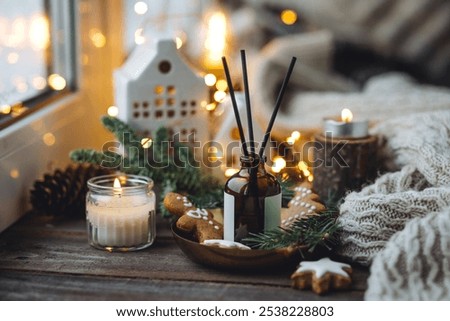 Aromatic home apartment diffuser with the fresh pine fragrance, gingerbread cookies scent. Fir tree branches, essential oils, candle, holiday decor. Cozy festive atmosphere, Christmas spirit