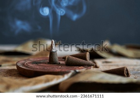 Aromatic incense cone and its smoke in a dark and intimate setting