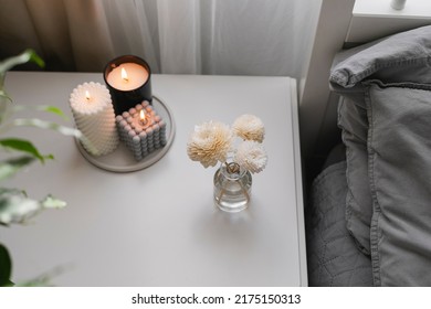 Aromatic Reed Air Freshener And Burning Candle On Bedside Table In The Bedroom. Home Aroma. Wellness