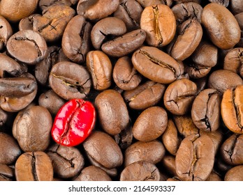 Aromatic roasted coffee beans with a red colored bean as eye catcher.