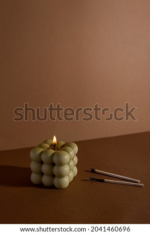 Aromatic scented soy candle with smoke on beige brown textile background , modern bubble candle still life