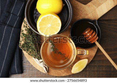 Aromatic thyme tea in cup, lemon and honey on table, top view