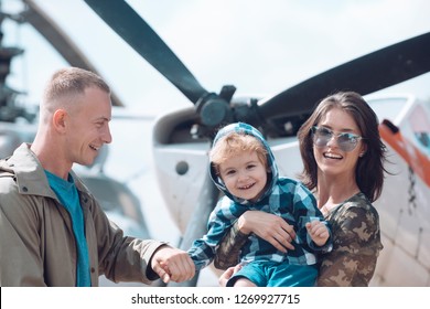 Around The World. Mother And Father With Son At Helicopter. Family Vacation. Family Couple With Boy Child On Vacation Trip. Helicopter Tour And Travel. Air Travel. Enjoying Travelling By Air.