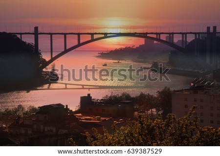 The Arrabida bridge over the Douro River in the rays of the setting sun. Porto, Portugal

