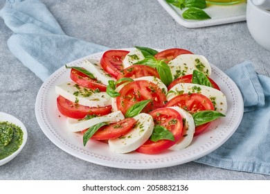 Arranged italian caprese salad in restaurant. Fresh mozarella, sliced tomatoes, basil leaf, olive oil. Organic and healthy. Homemade crushed pesto sauce. Traditional recipe. Mediterranean cuisine - Powered by Shutterstock