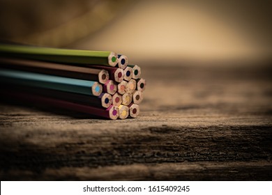 Arrangement Of Colored Pencils On A Dark Brown Wooden Table. Cinematic Concept To Keep On Being Creative And A Way To Motivate Children To Continue Their Education.