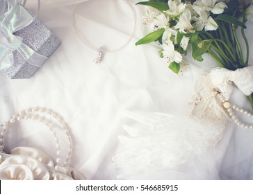 Arrangement Of Flower Bunch, Pearl Necklace, Gift Box, Bag, And Lace Glove On White Cloth Background, Romantic Concept, Frame, Copy Space