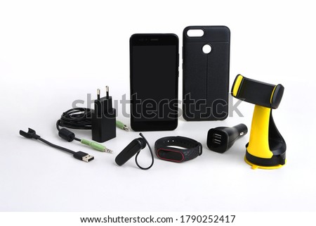 Arrangement of mobile accessories used in the car, including charger, handsfree, holder and stereo cable