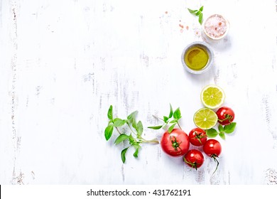 An arrangement of tomatoes, basil, olive oil and himalayan salt. Concept for healthy nutrition. White wooden background. Top view. Copy space.  - Shutterstock ID 431762191