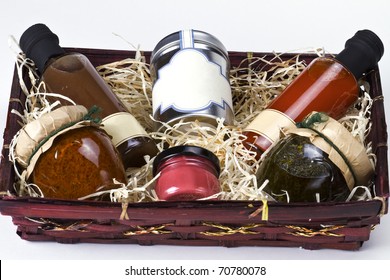 An Arrangement Of Various Gourmet Condiments In A Gift Basket.