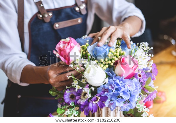 Arranging artificial flowers vest decoration at\
home, Young woman florist work making organizing diy artificial\
flower, craft and hand made\
concept.