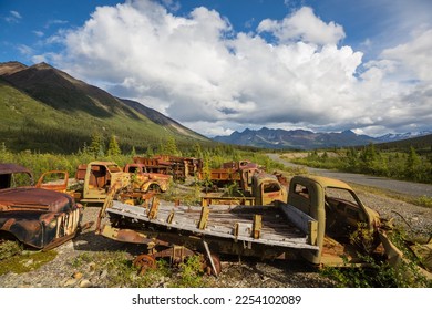 An array of abandoned rusty post war trucks that lay rusting away in the wilderness during summer time in northern Canada - Shutterstock ID 2254102089