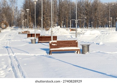Array of the benches in a park covered with snow