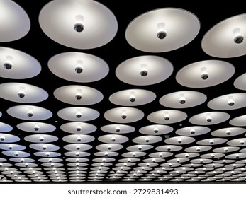 An array of ceiling light fixtures extend into the distance in the lobby of building in New York City.