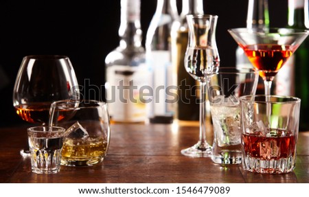 Variety of glasses with various cocktails placed on stripes surface