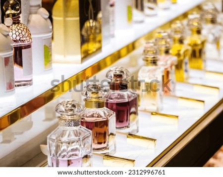 Array of elegant crystal perfume bottles in a row, displaying various fashionable scents and alluring aromas in a high-end store.