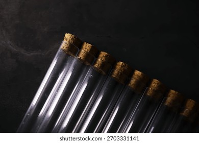 Array of Empty Glass Test Tubes with Cork Stoppers on Dark Surface