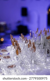 An array of exquisite crystal cut glasses filled with ice and garnishes, ready for a celebratory cocktail occasion