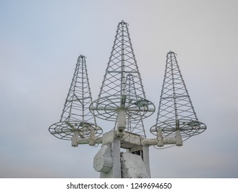 Array of four helical antennas used for satellite tracking. Antennas directed to sky. Closeup view.