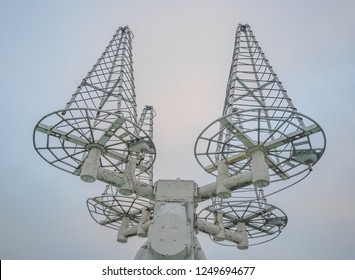 Array of four helical antennas used for satellite tracking. Antennas directed to sky. Closeup view.