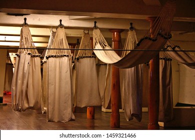Array of hammocks in the trunk of an old sail ship used by sailors for sleeping in common room
