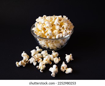 An array of popcorn kernels, nestled in a glass bowl, against a black canvas background - Shutterstock ID 2252980253