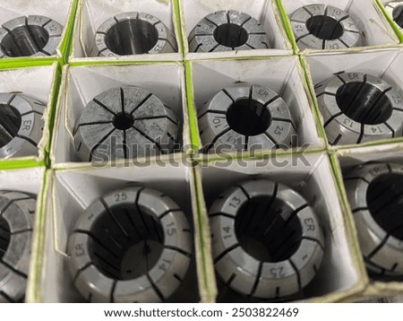 Array of precision metal collets neatly stored in individual compartments, highlighting the importance of organization in industrial tooling
