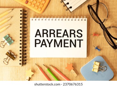 Arrears Payment write on a book isolated on Wooden Table