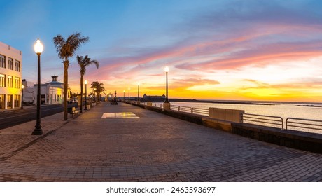 The Arrecife promenade in Lanzarote offers stunning ocean views at sunset, with palm trees, street lights and a romantic atmosphere ideal for relaxing walks. - Powered by Shutterstock