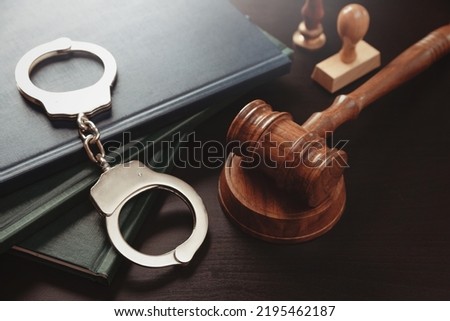 Arrest concept. Metal handcuffs near judge gavel. Law and justice concept